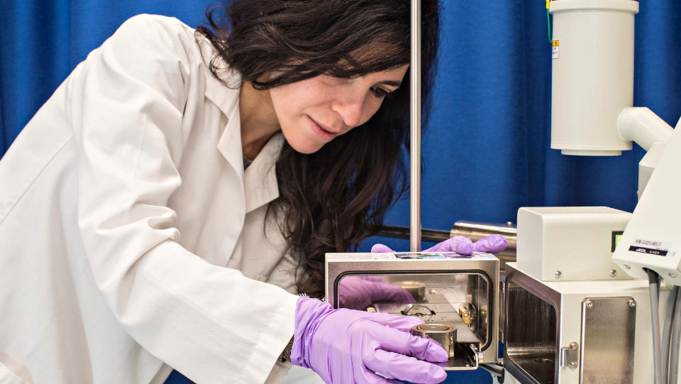 A woman with purple gloves on in a science lab